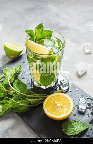 Fresco cocktail estivo alcolico mojito con ghiaccio, menta fresca e lime. Foto Stock