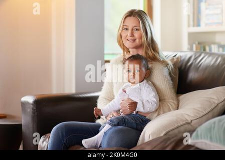 E due fanno una famiglia. Ritratto ritagliato di una madre e del suo figlio adottiva. Foto Stock