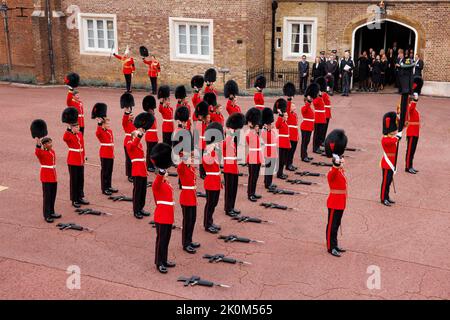 I membri delle guardie del Coldstream alzano le loro pelli e danno tre saluti al Re mentre prendono parte alla cerimonia di proclama a Friary Cou Foto Stock