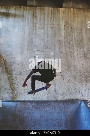 La vita è migliore quando hai sfratto. Un giovane che fa trucchi sul suo skateboard allo skatepark. Foto Stock