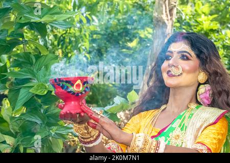 Donne sposate che eseguono dhunuchi danza in occasione di Durga Agomoni come rituale, il fumo Santo copriva tutta la zona. Foto Stock