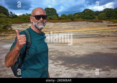 L'escursionista visita la caldera, un piccolo cratere circolare con una palude di acque sulfuree, testimonianza dell'antica presenza di un vulcano. Foto Stock