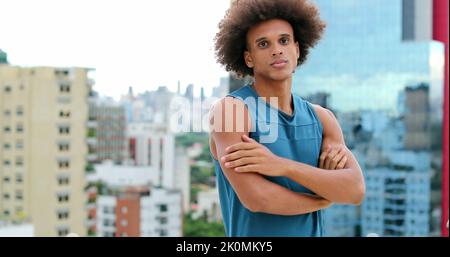 Sportivo Ritratto di giovane bell'uomo americano di razza mista che guarda alla macchina fotografica con le braccia incrociate Foto Stock