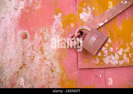 Una vecchia serratura su una piccola porta di un contenitore di risone in tropicale contrario. A causa di lunga permanenza ottiene ruggine e funghi su di esso Foto Stock