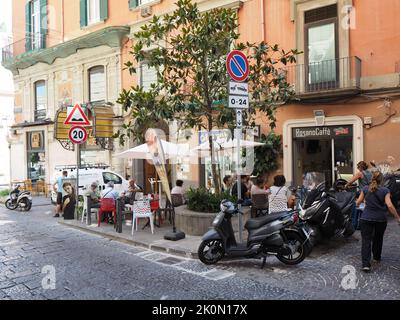 Tipica scena di strada napoletana con persone che socializzano e che hanno un caffè, e scooter parcheggiati ovunque. Napoli, Campania, Italia Foto Stock