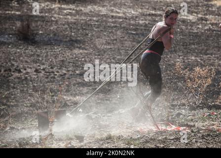 Merida, Spagna - 11th settembre 2022: FarinatoRace Merida 2022. Donna che trascina pezzo di trave in acciaio Foto Stock