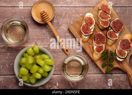 Fotografia gastronomica di bruschetta, fico, ricotta, uva, vino, miele, formaggio Foto Stock