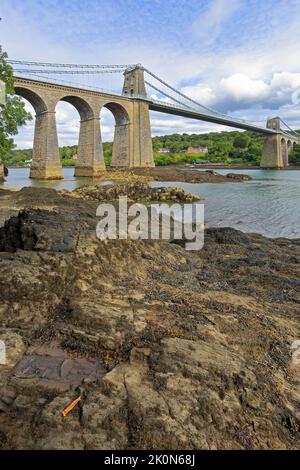 Ponte sospeso Menai di Thomas Telford, Pont Menai, dallo stretto di Menai, dal Ponte Menai, dall'Isola di Anglesey, da Ynys Mon, Galles del Nord, REGNO UNITO. Foto Stock