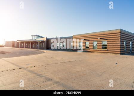 Esterno di un moderno edificio scolastico sotto il cielo limpido al tramonto. Concetto di ritorno a scuola. Foto Stock