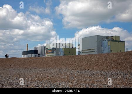 Due persone camminano davanti alla centrale nucleare di Dungeness, Kent, Inghilterra. Foto Stock