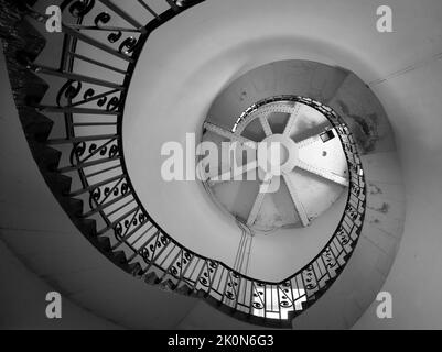 Immagine monocromatica della scala a chiocciola all'interno del vecchio faro di Dungeness, Kent, Inghilterra. Foto Stock