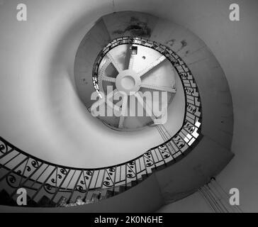 Immagine monocromatica della scala a chiocciola all'interno del vecchio faro di Dungeness, Kent, Inghilterra. Foto Stock