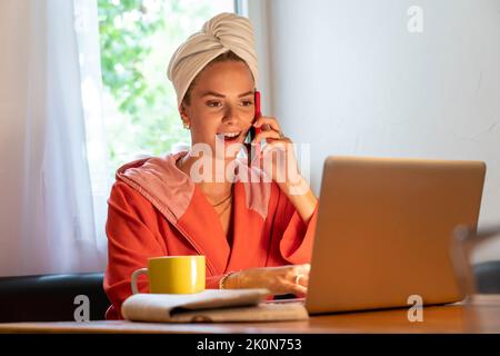 Immagine simbolica Precrastinazione, giovane donna cerca di fare molte cose allo stesso tempo, dopo il bagno, sul computer, telefono, giornale, e colazione Foto Stock