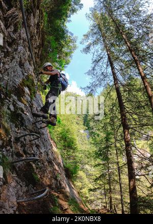 Donna che arrampica sul MÃ¼rren-Gimmewald Via Ferrata, Svizzera Foto Stock