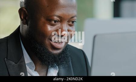 Primo piano lavoratore maschile uomo afroamericano barbuto uomo d'affari ragazzo specialista lavoro su laptop in ufficio chat con i colleghi digitando Foto Stock