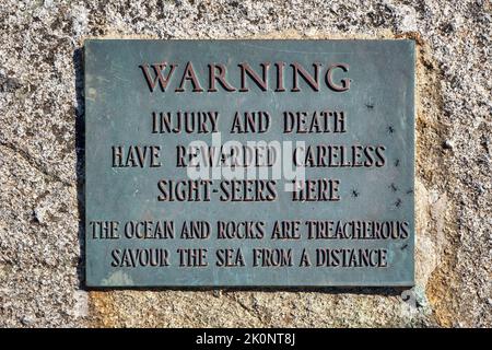 Segnale di avvertimento visitatori a Pegg'y Cove circa i pericoli delle rocce e l'oceano. Numerose persone sono state ferite e alcune sono morte a e intorno Foto Stock