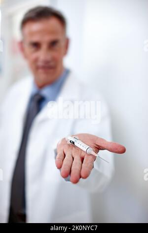 Sorridete e non vi sentirete una cosa. Colpo di primo piano di un medico che tiene in mano una siringa. Foto Stock