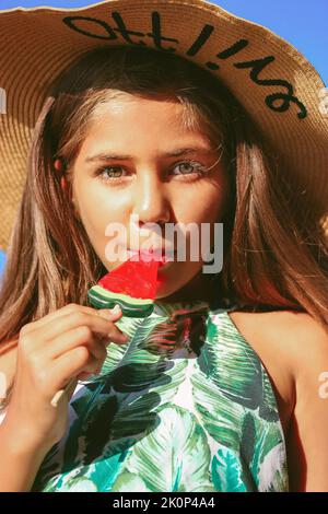 Bella ragazza adolescente mangia anguria lollipop in estate felice bambino con caramelle Foto Stock