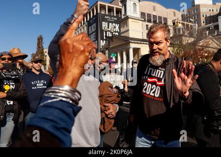 Washington, DC, Stati Uniti. 13th Nov 2020. Un sostenitore di Trump nutra un attivista anti-razzismo in Black Lives Matter Plaza circa 40-50 sostenitori di Trump si sono riuniti in piazza prima del milione DI MAGA/Stop the Steal March il giorno seguente. Hanno tentato senza successo di provocare lotte contro i controppositori antirazzisti, ma hanno rimosso l'arte di protesta antirazzista dalla Black Lives Matter Memorial Fence. (Credit Image: © Allison Bailey/SOPA Images via ZUMA Press Wire) Foto Stock