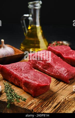 Vista in primo piano del lombo di bistecca crudo disossata con spezie sul tagliere Foto Stock