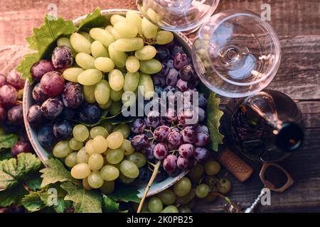 Bicchieri da vino e uva su tavola in legno. Foto di alta qualità Foto Stock