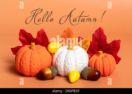 Zucche, foglie di acero, acorni e bacche su sfondo arancione stagione autunnale Ciao settembre, ottobre, novembre concetto piatto Lay Top view. Foto Stock