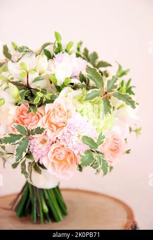 Bouquet rotondo di nozze con fiore bianco di freesia, dianthus verde, rose di pesca, crisantemo chiaro e verdi freschi. Bouquet nuziale e legno su ba rosa Foto Stock