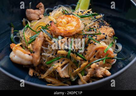 Vermicelli di riso con gamberetti, carne e spezie, su cemento grigio Foto Stock