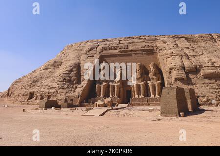 La vista principale di un ingresso al Grande Tempio di Abu Simbel con antiche statue colossali di Ramesse II, sedute su un trono e indossate la doppia Foto Stock