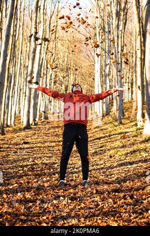 Il giovane uomo attivo ama la stagione autunnale nelle montagne ceche in mezzo all'Europa. Un novembre perfetto con foglie colorate. La gioia di Foto Stock