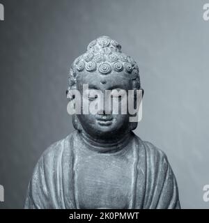 Statua di Siddharha Gautama Buddha fatta di pietra grigia come decorazione interna Foto Stock