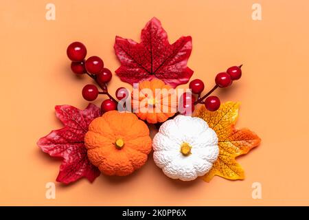 Autunno bouquet di acorns, bacche, foglie di acero, zucche isolato su sfondo arancione piatto Lay Top view Floral Border Holiday card Ciao settembre, ottobre, novembre concetto. Foto Stock