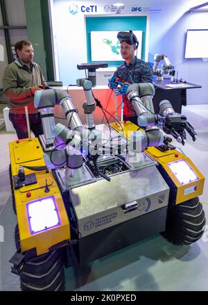 13 settembre 2022, Sassonia, Lipsia: Mikhail Belov (l) e Dominik Grzelak dell'Università tecnica di Dresda presentano i loro lavori sul cosiddetto "progetto Sniffbot" al Robotics Festival di Lipsia. Utilizzando occhiali VR e guanti appropriati, un operatore controlla un robot per rilevare le perdite di gas. Secondo l'organizzatore, il festival riunisce oltre 400 decision-makers internazionali, utenti, scienziati, investitori e le prime 30 startup nel settore della robotica. Approcci e applicazioni che stanno plasmando il mondo del lavoro nell'industria, nelle piccole e medie imprese e nello sci Foto Stock