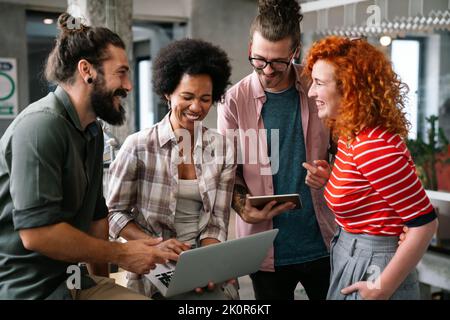 Diversi gruppi di professionisti che si incontrano in ufficio. I programmatori IT utilizzano il computer, parlano la strategia Foto Stock