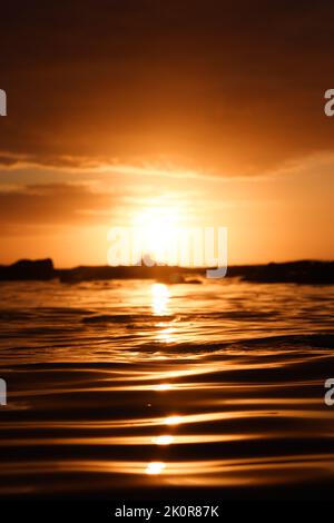 Una vista ipnotica di un tramonto epico sul mare. Scatto verticale Foto Stock