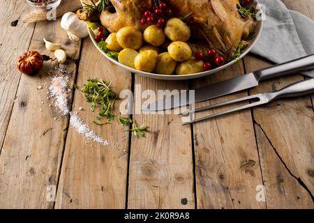 Vista dall'alto del tacchino arrosto da tavola del ringraziamento, patate, decorazione autunnale e spazio copia su legno Foto Stock