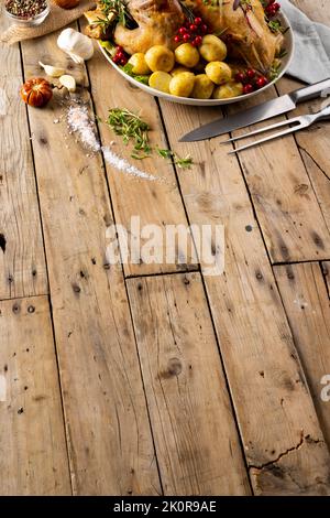 Vista dall'alto del tacchino arrosto da tavola del ringraziamento, patate, decorazione autunnale e spazio copia su legno Foto Stock