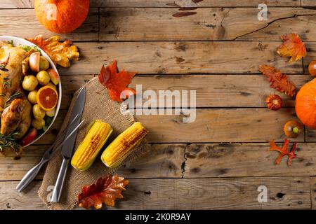 Vista dall'alto del tacchino arrosto da tavola del ringraziamento, patate, decorazione autunnale e spazio copia su legno Foto Stock