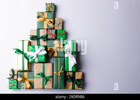 Immagine dei regali di natale che formano l'albero di natale e lo spazio della copia su sfondo grigio Foto Stock