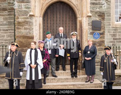 Il Clerk del comune di Tavistock, Carl Hearn, ha letto la proclamazione dei passi della Guildhall, insieme a dignitari e dirigenti civici, tra cui Ric Cheadle (Vice Presidente del Devon), il Consigliere James Ellis (Vice Sindaco di Tavistock), il Consigliere Caroline Mott (Sindaco del Devon occidentale), il Consigliere della contea Debo Sellis, Reverendo Rosie Illingworth, accompagnato dai portacolori del Mace della Città Foto Stock