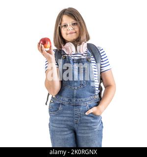 Ragazza rotonda in occhiali e cuffie sul collo tiene in mano una mela rossa. Foto Stock