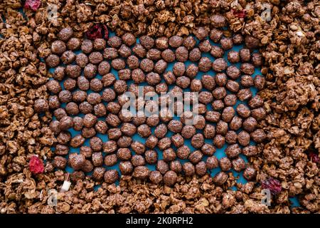 vista dall'alto di gustose palle di cereali vicino al croccante granola di cioccolato, immagine stock Foto Stock