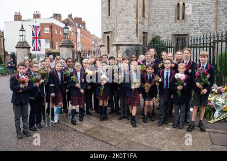 Windsor, Berkshire, Regno Unito. 13th Settembre 2022. I bambini di scuola anni 7 e 8 alla St George's School Windsor Castle vennero a porre tributi floreali in memoria della defunto Regina Elisabetta II oggi fuori dalle porte del Castello di Windsor sulla Long Walk. Credit: Maureen McLean/Alamy Live News Foto Stock