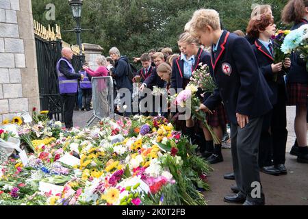 Windsor, Berkshire, Regno Unito. 13th Settembre 2022. I bambini di scuola anni 7 e 8 alla St George's School Windsor Castle vennero a porre tributi floreali in memoria della defunto Regina Elisabetta II oggi fuori dalle porte del Castello di Windsor sulla Long Walk. Credit: Maureen McLean/Alamy Live News Foto Stock