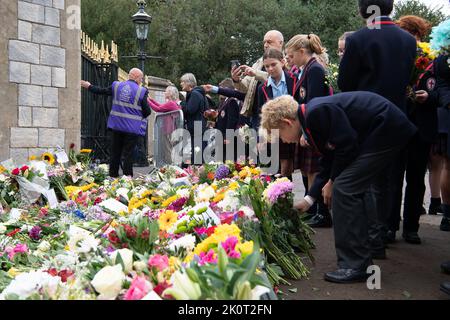 Windsor, Berkshire, Regno Unito. 13th Settembre 2022. I bambini di scuola anni 7 e 8 alla St George's School Windsor Castle vennero a porre tributi floreali in memoria della defunto Regina Elisabetta II oggi fuori dalle porte del Castello di Windsor sulla Long Walk. Credit: Maureen McLean/Alamy Live News Foto Stock