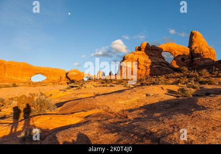 Moon Over the North Window, South Window e Turret Arch nella sezione Windows del parco nazionale di Arches, Moab, Utah. Ombre di due fotografi pho Foto Stock