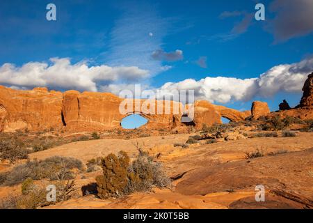 Luna sopra le finestre Nord e Sud, archi di arenaria nella sezione Finestre del Parco Nazionale Arches, Moab, Utah. Foto Stock