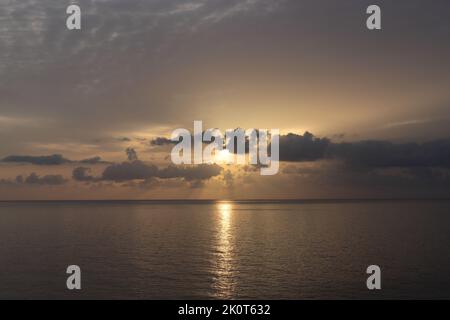 Sole che sorge e nuvole scure sul mar mediterraneo, Cala Ratjada, Maiorca Foto Stock