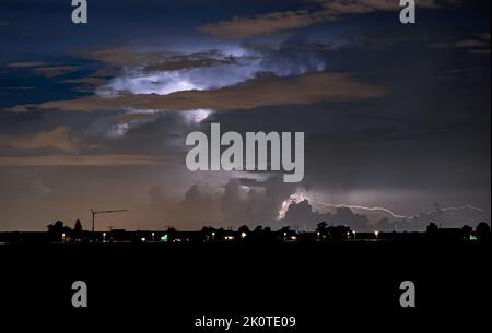 La tempesta sui Paesi Bassi occidentali è illuminata dall'interno da lampi di fulmini. A volte un canale dei fulmini è visibile fuori dalla tempesta. Foto Stock