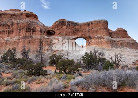 Tunnel Arch arroccato sulle scogliere di arenaria sopra il paesaggio. Arches National Park, Utah Foto Stock